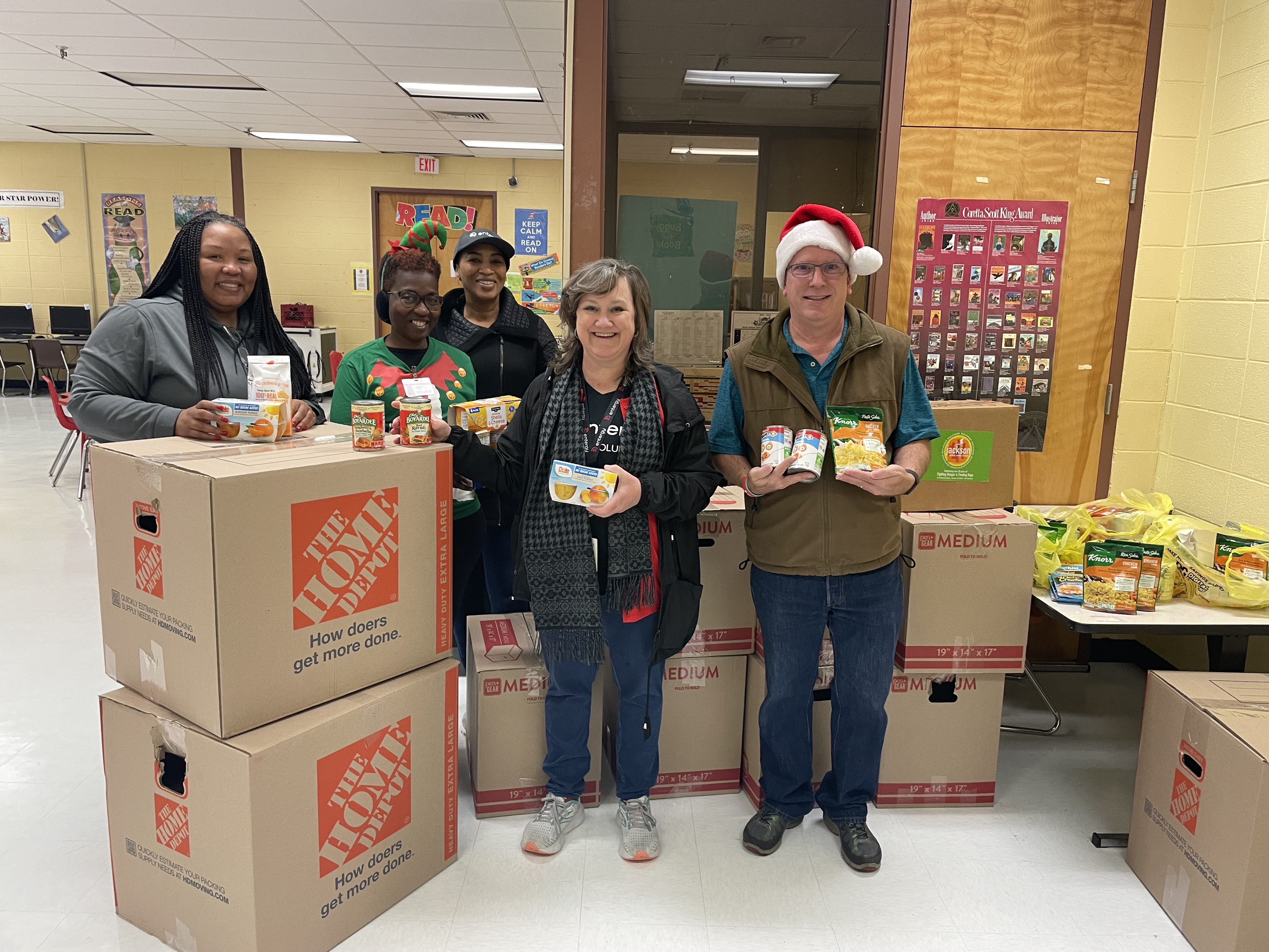(From left) Jocelyn Smith, principal, North Jackson Elementary School; Stacy Dawson, North Jackson Elementary; Donicia Thompson, Entergy; Tamara May, Entergy, and Mark Bain, Entergy, stand with the supplies Entergy Nuclear employees collected for a food drive to support the school’s families during the holidays. 