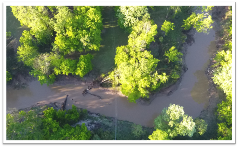 An aerial photo from a drone shows a large tree leaning on a distribution line in a flooded area. The images allowed Entergy to develop a plan to enter the area safely and remove the tree.