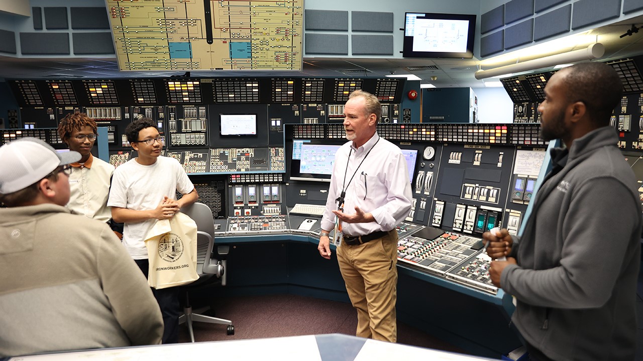 Instructor Jay Comfort gives students a tour of Grand Gulf Nuclear Station's simulator while teaching them about the job of an operator.
