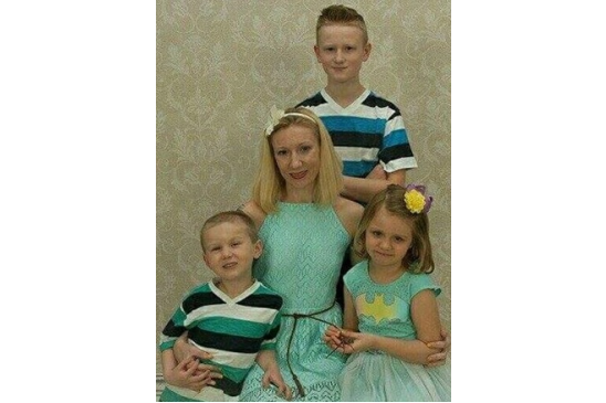 Photo of Larissa with her children: youngest son, Elijah, daughter, Emma Jean, and oldest son, Connor, standing in back. Photo of Larissa with her children: youngest son, Elijah, daughter, Emma Jean, and oldest son, Connor, standing in back.