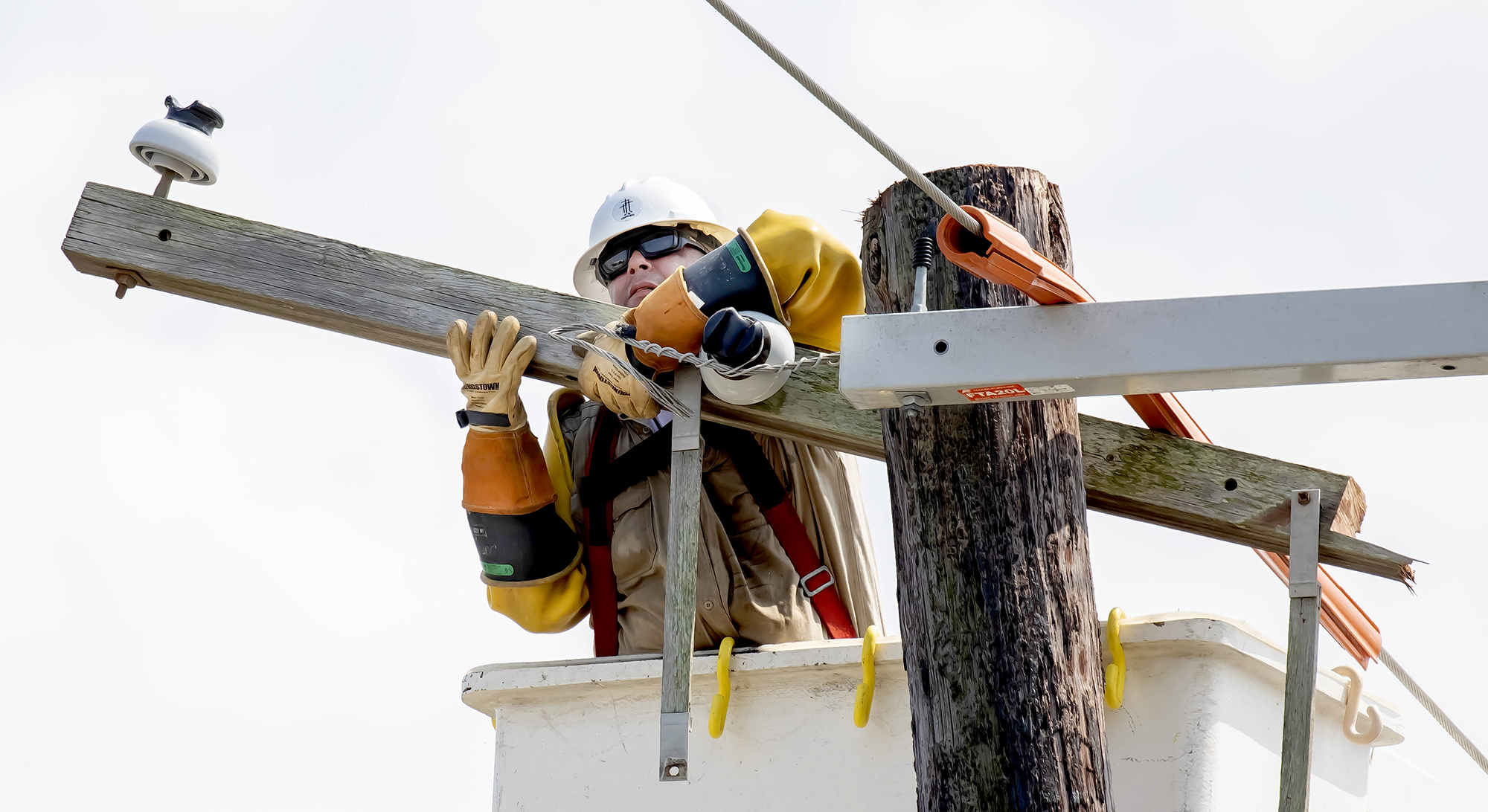 A line worker with PSC Primoris, working for Entergy, handles a crossarm while moving conductors from a broken pole to a new one in Gretna Thursday. 