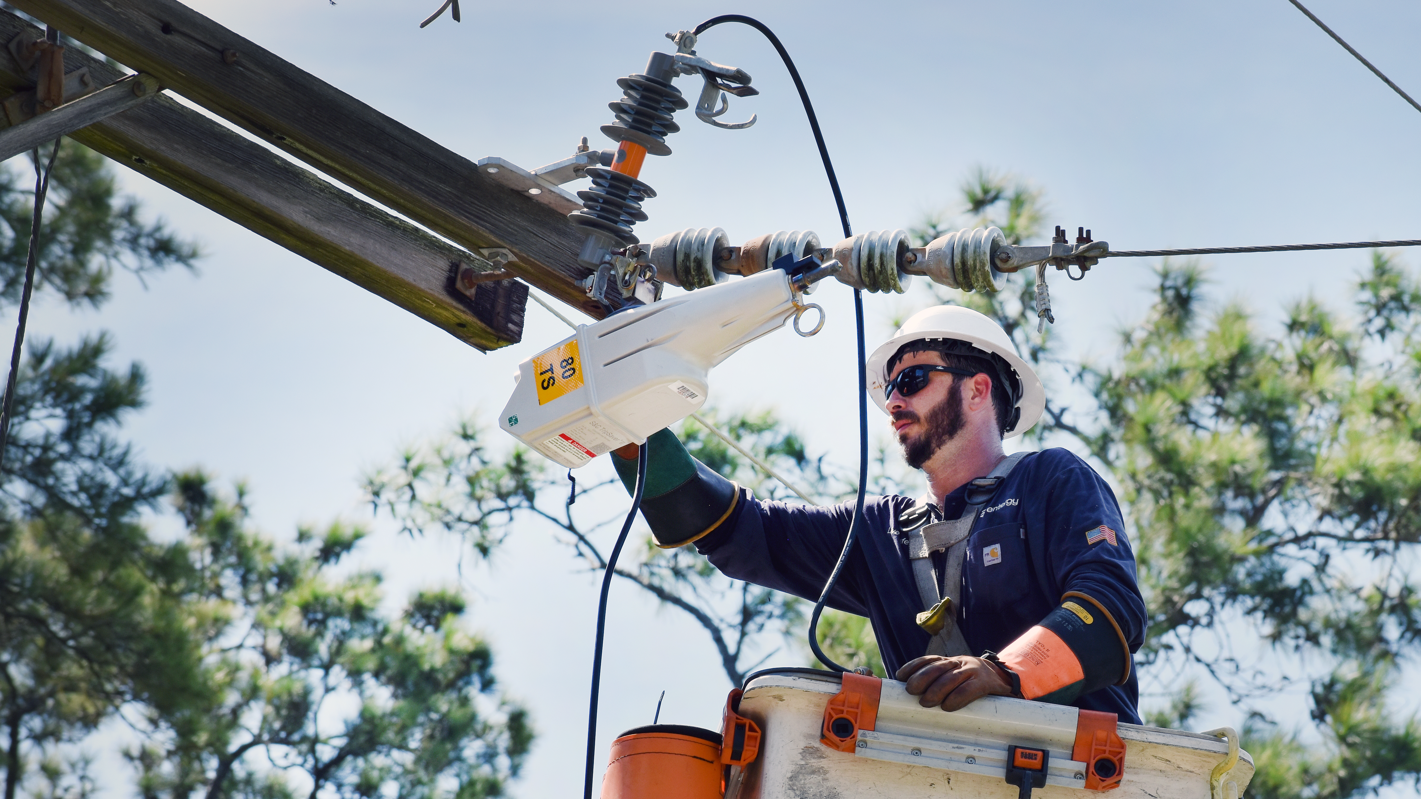 Jason Daniels, an Entergy Louisiana lineworker based out of the Bogalusa area, installs a programmable device at the intersection of Frederick and Morris roads in Hammond.  