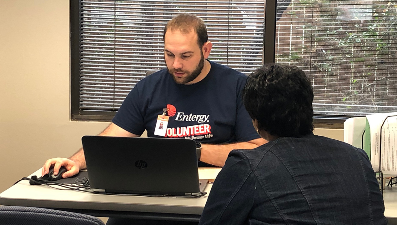 Entergy's Mark Delavan helps prepare a customer's taxes.