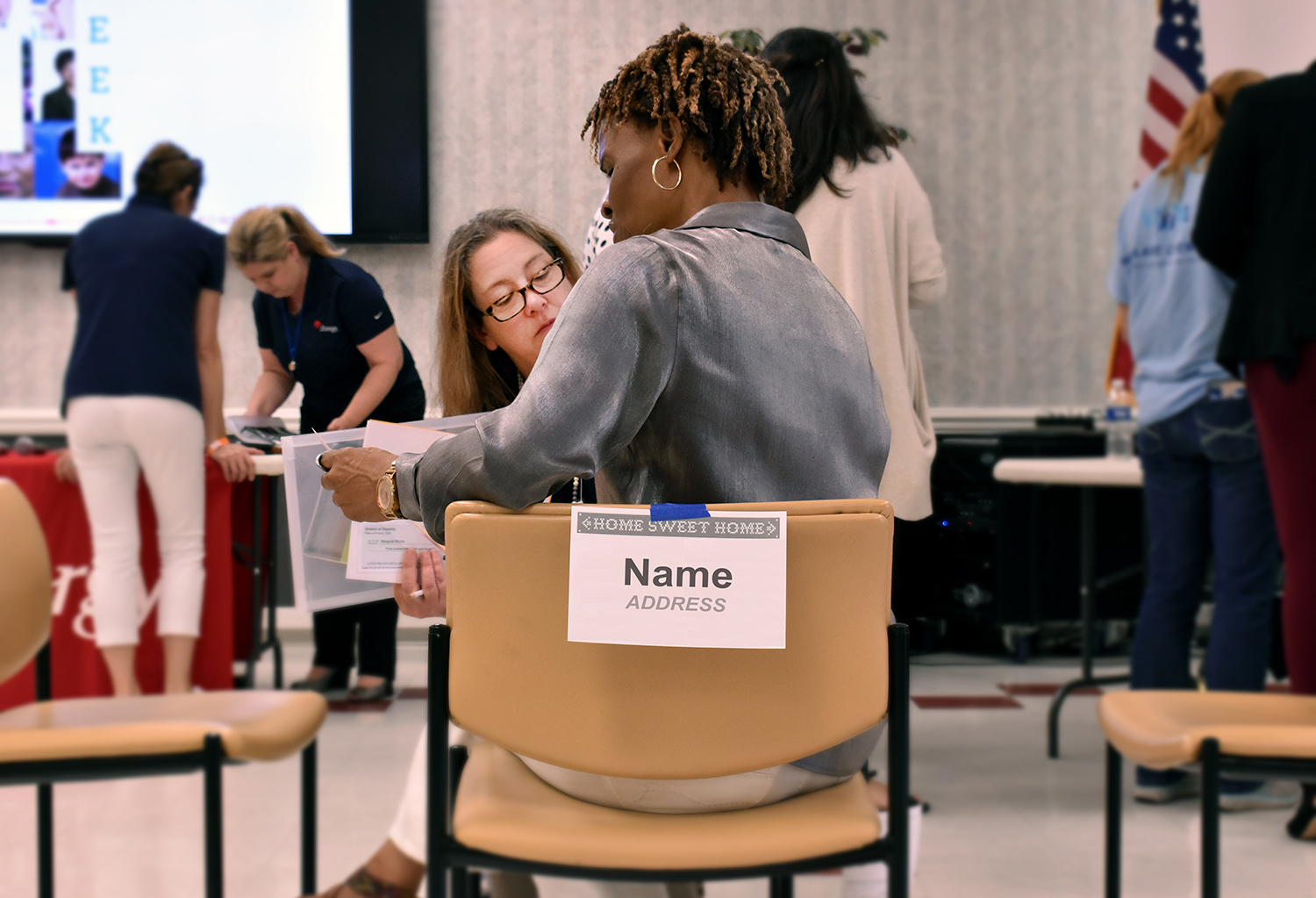 Shelly Mayo, Calcasieu Police Juror – District 3 and Dawn Frederick, a Calcasieu Parish Police Jury accounting department employee, look through paperwork as the Community Action Poverty Simulation begins at American Job Center in Lake Charles.