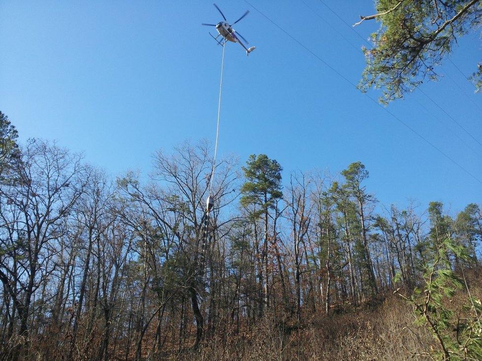 Air saws guided by helicopters help Entergy Corporation trim hard-to-reach trees and vegetation, minimizing the risk of power outages caused by falling trees and limbs.